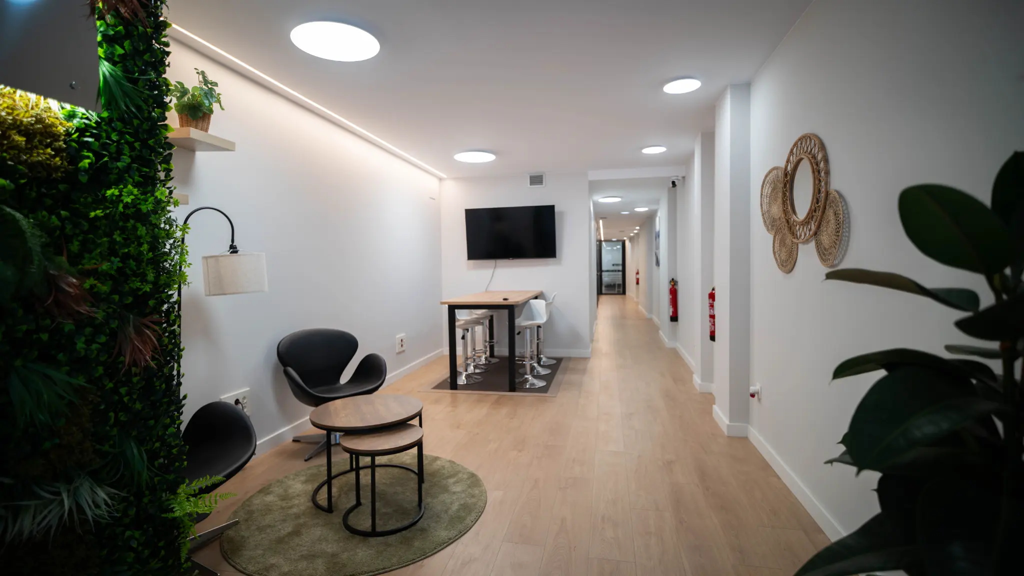 Espacio común con mesa alta, TV y decoración natural